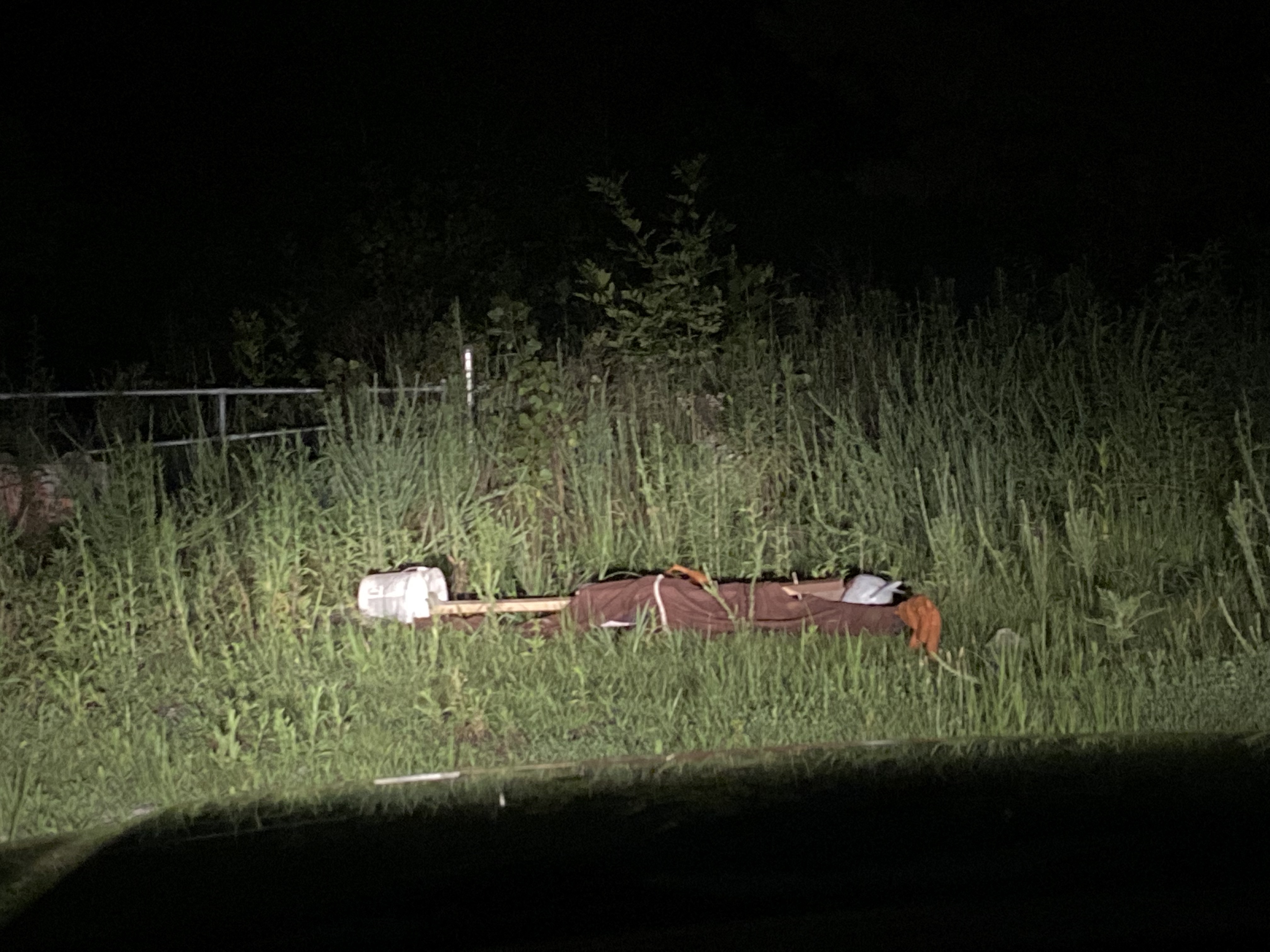 Scarecrow face planting on the floor, car headlights illuminate it