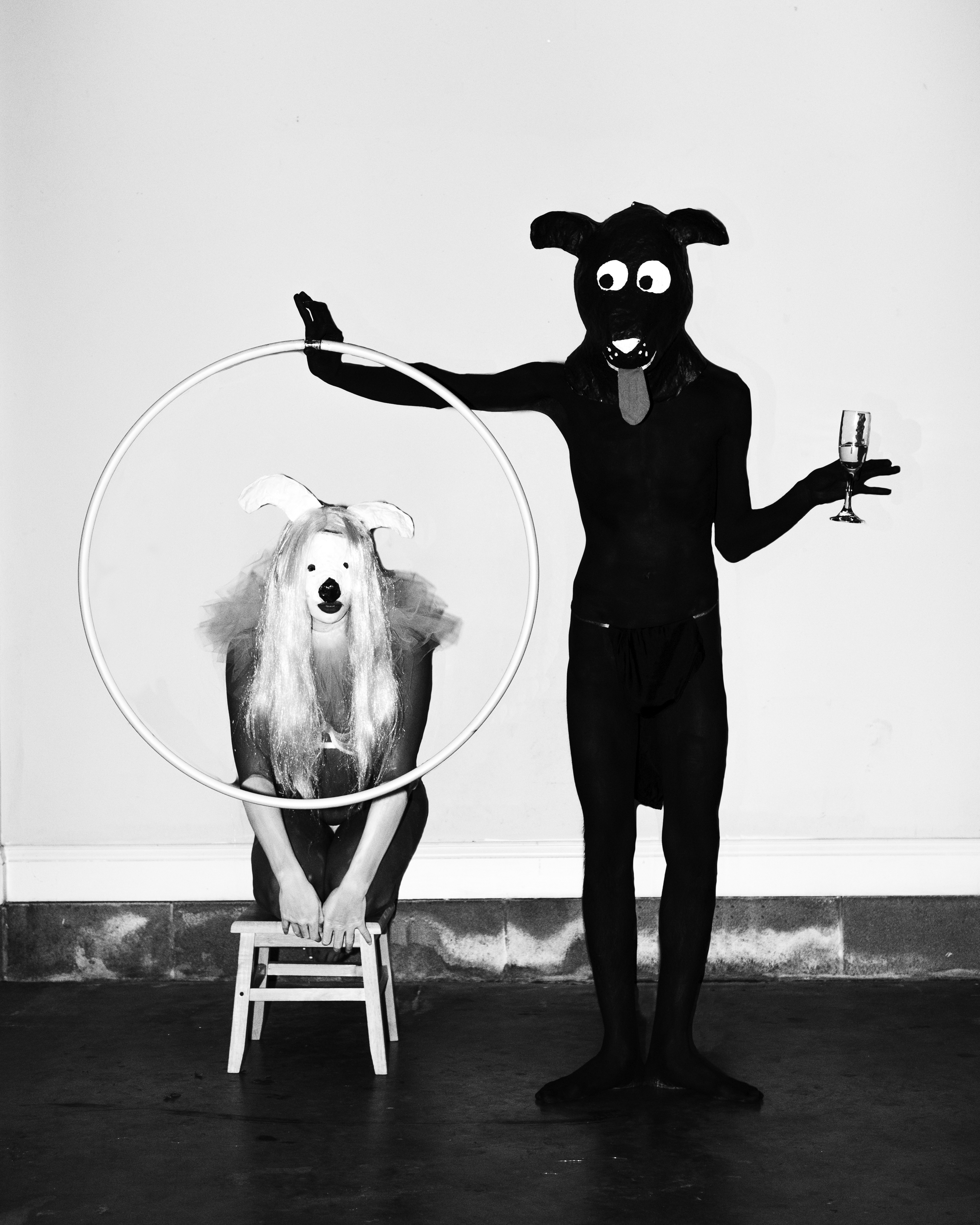 A black humanoid dog holds a ring in front of a humanoid dog woman